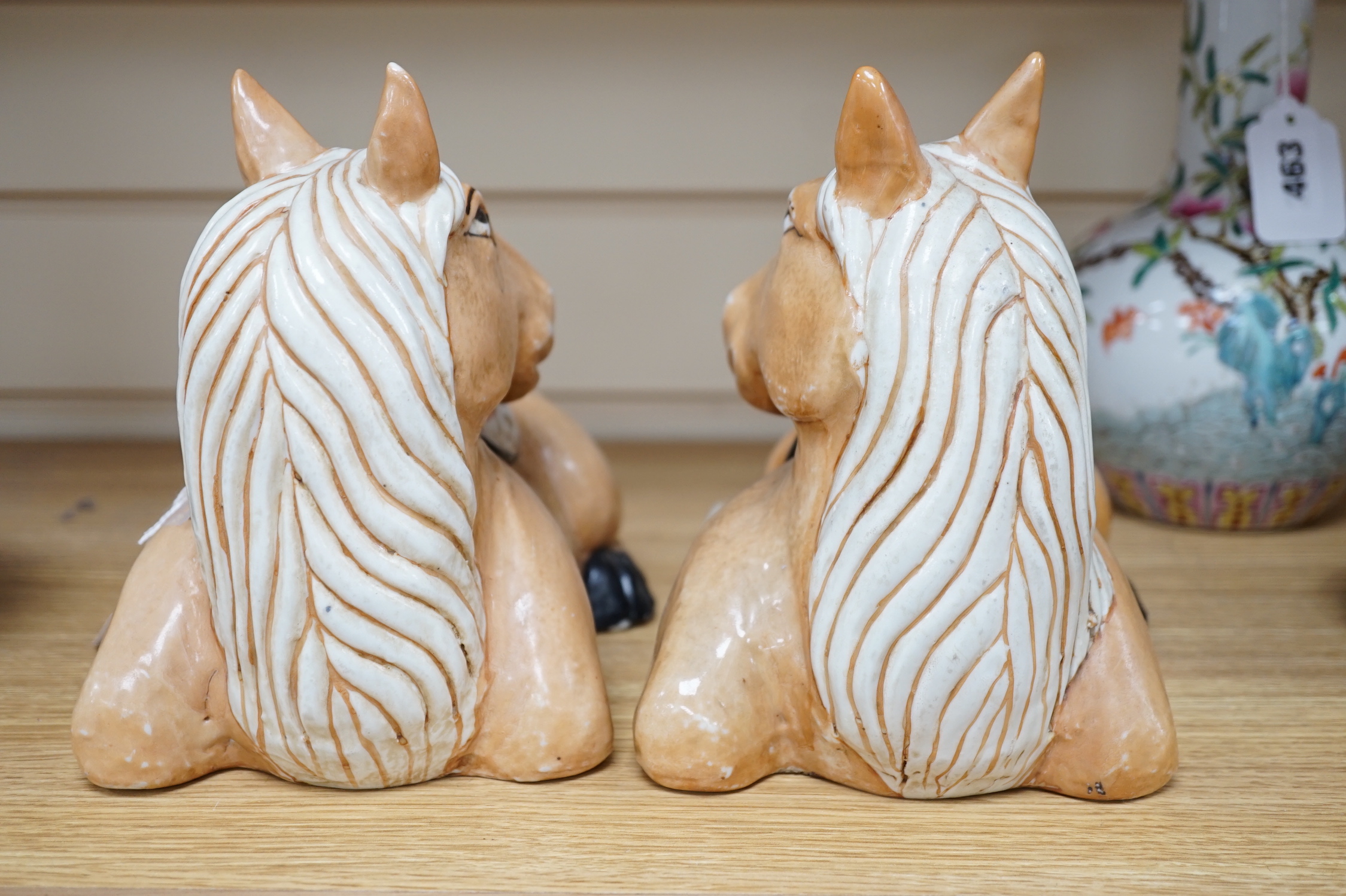 A pair of Chinese ceramic seated horses, 18cm high
